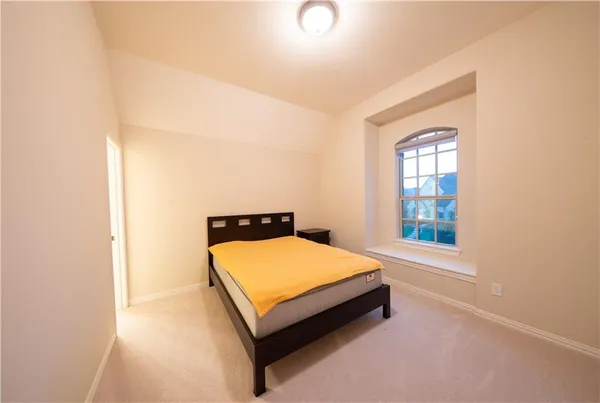 a bed sitting in a bedroom next to a window