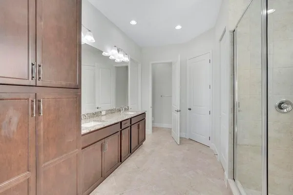 a bathroom with a double vanity sink mirror and shower