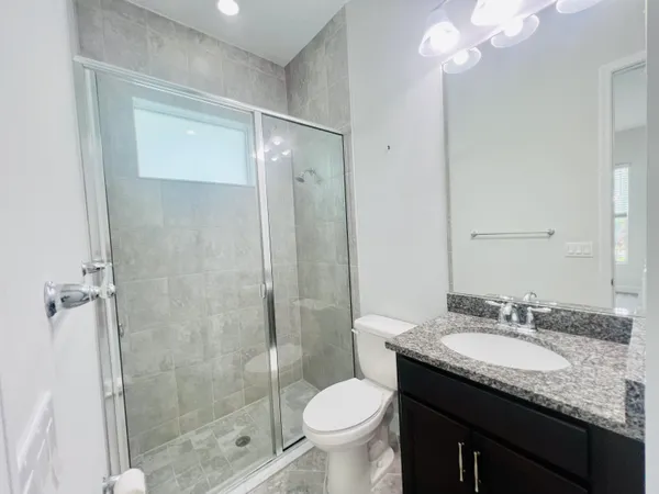 a bathroom with a granite countertop sink toilet and shower
