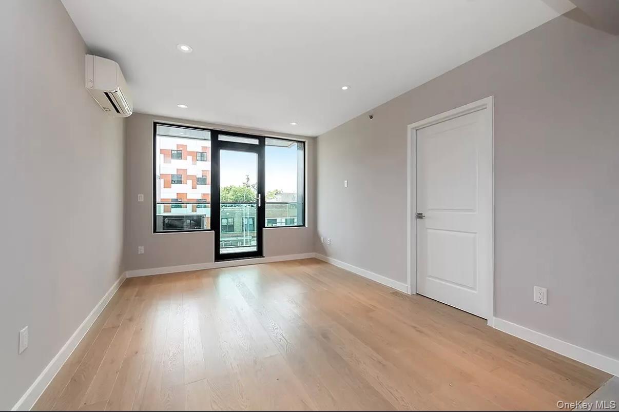 32-58 105th Street, Unit 4A Queens, NY 11369 - Photo 4 of 8 Spare room with light wood-type flooring, an AC wall unit, and recessed lighting