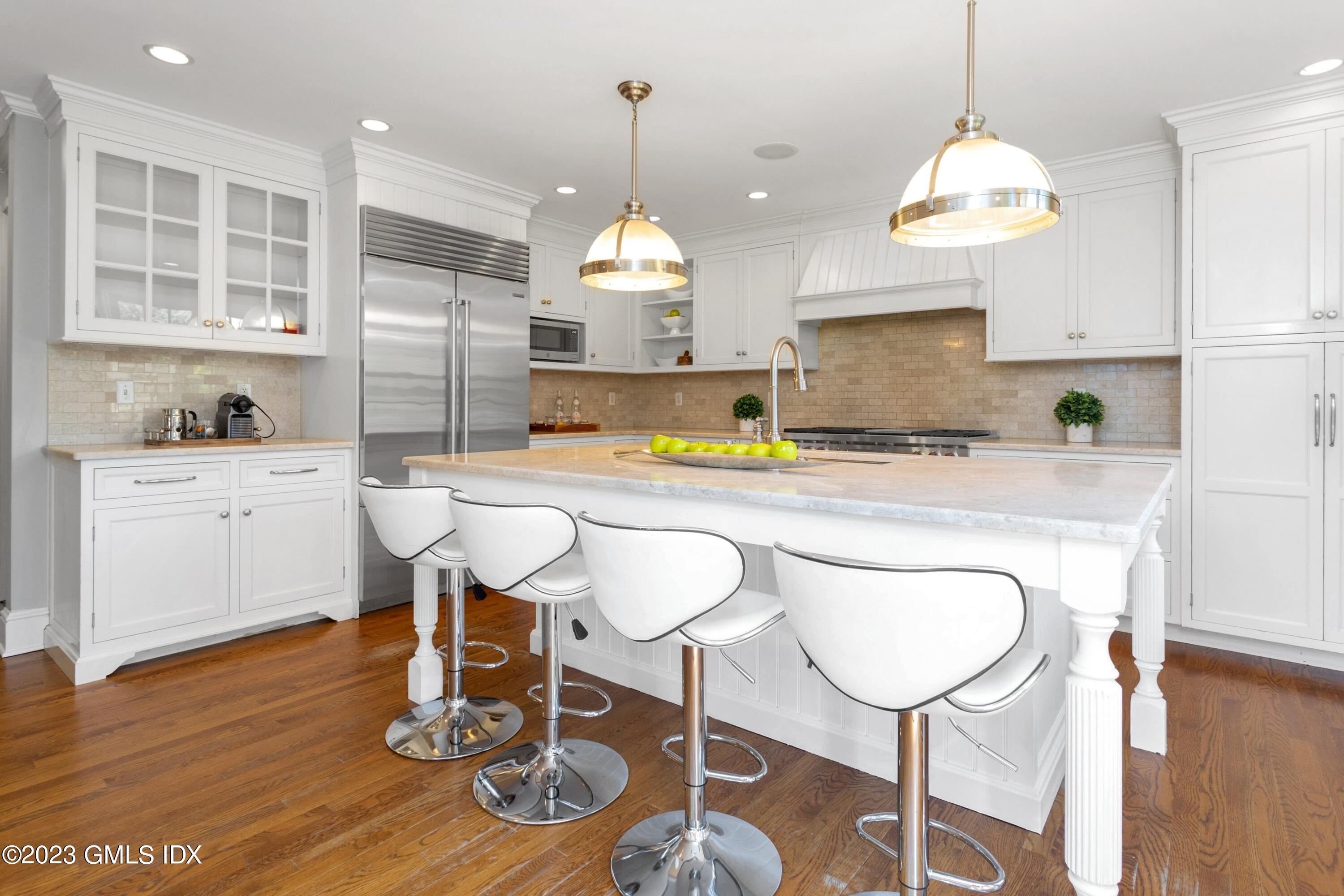 7 Colonial Lane Riverside, CT 06878 - Photo 5 of 27 a kitchen with a dining table cabinets and wooden floor