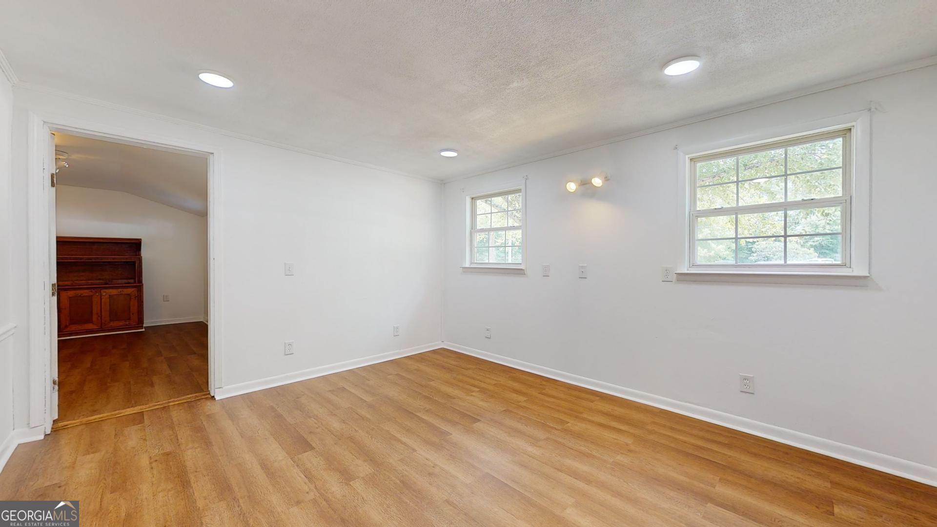 623 Virginia Avenue Millen, GA 30442 - Photo 22 of 34 an empty room with wooden floor and windows