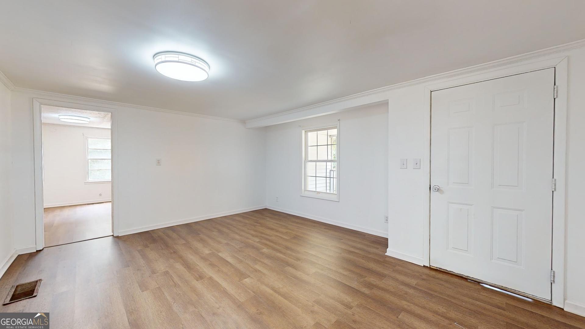 623 Virginia Avenue Millen, GA 30442 - Photo 4 of 34 wooden floor in an empty room with a window