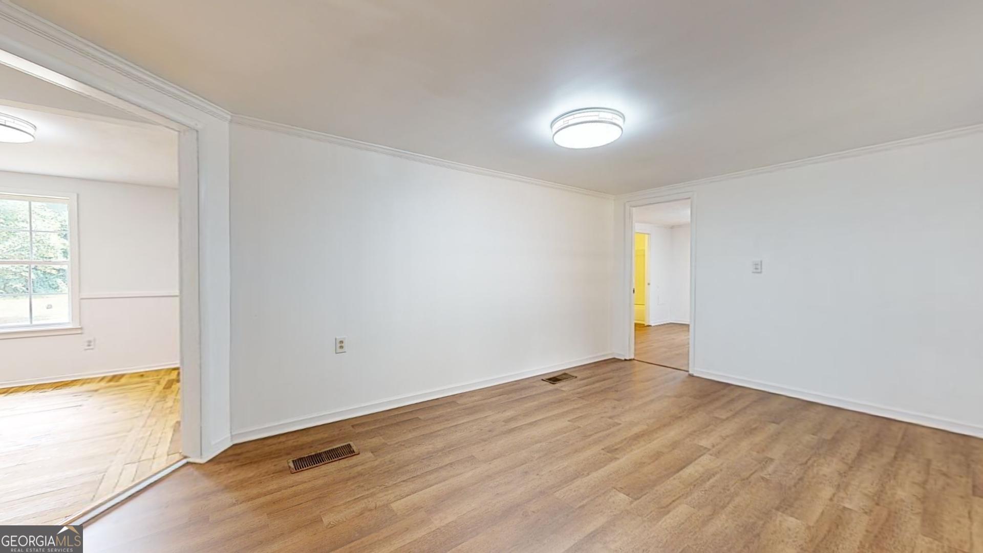 623 Virginia Avenue Millen, GA 30442 - Photo 5 of 34 an empty room with wooden floor and windows