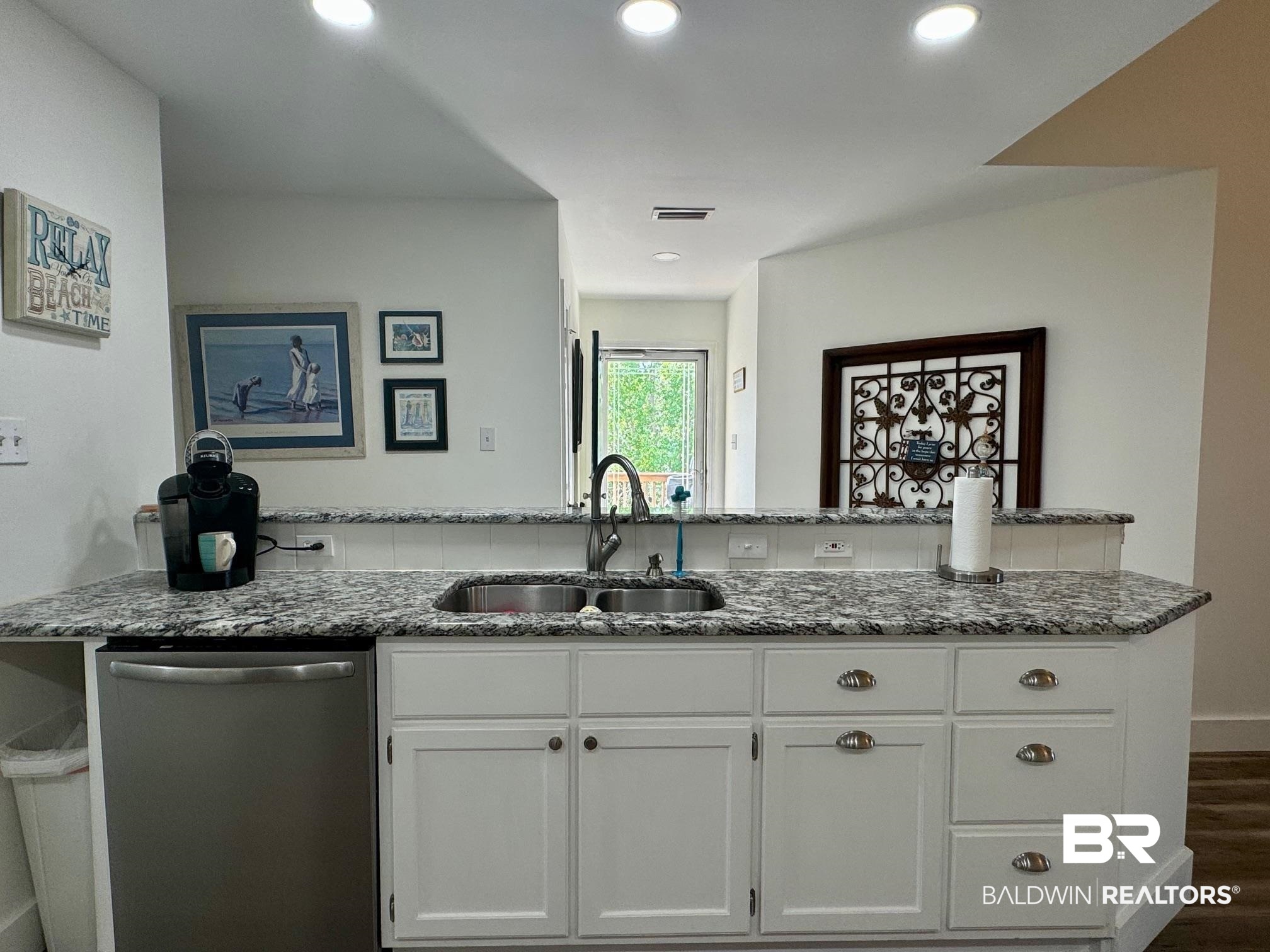 3200 Loop Road, Unit 55 Orange Beach, AL 36561 - Photo 10 of 40 Kitchen featuring dishwasher, stone counters, sink, and white cabinetry