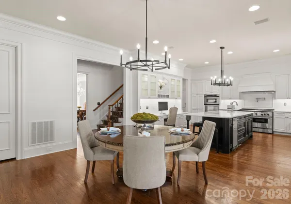 a dining room with furniture a chandelier and wooden floor