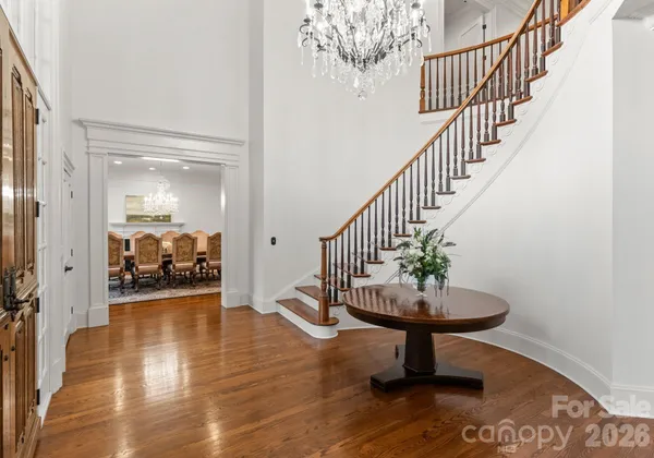 a view of a hallway with wooden floor and a living room