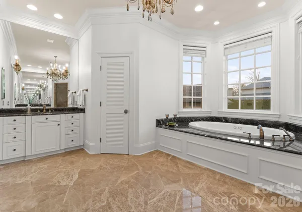 a bathroom with a granite countertop tub sink and mirror