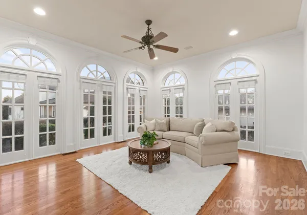 a living room with furniture potted plant and a large window