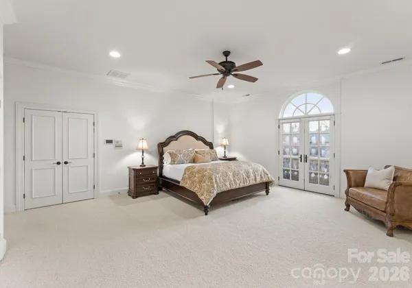 a bedroom with a bed a couch and a chandelier