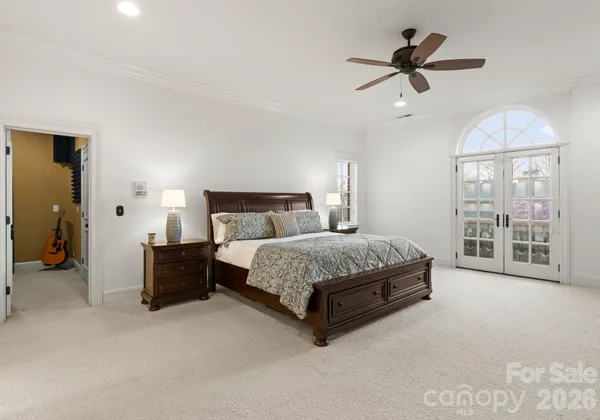 a bedroom with a large bed and a chandelier