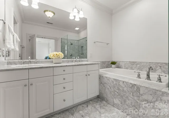 a bathroom with a granite countertop double vanity sink mirror and bathtub