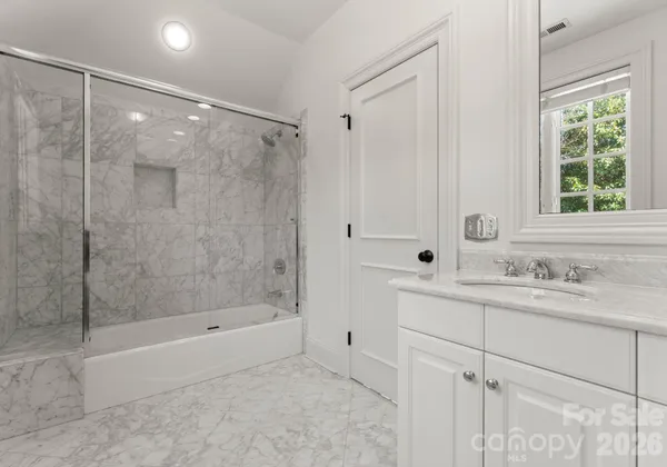 a bathroom with a shower sink and mirror