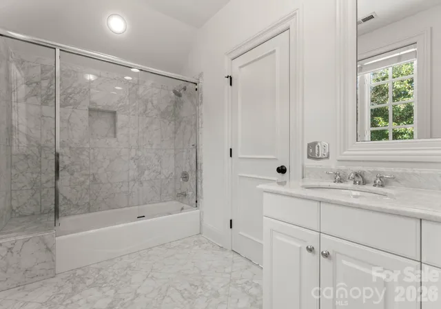 a bathroom with a shower sink and mirror