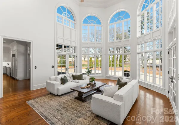 a living room with patio furniture and floor to ceiling windows