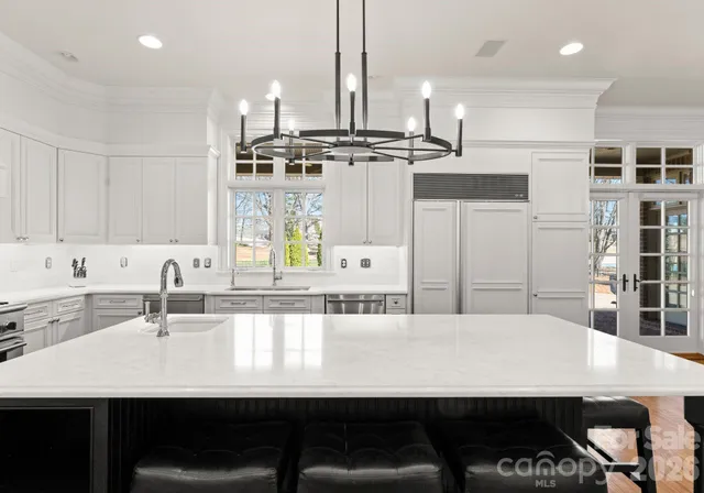 a kitchen with kitchen island stainless steel appliances a sink and cabinets