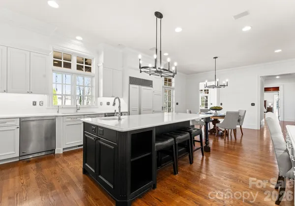 a kitchen with a dining table chairs sink and stove