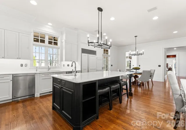 a kitchen with a dining table chairs sink and stove