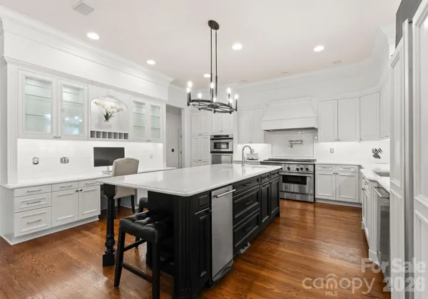 a large kitchen with kitchen island a large island in white appliances