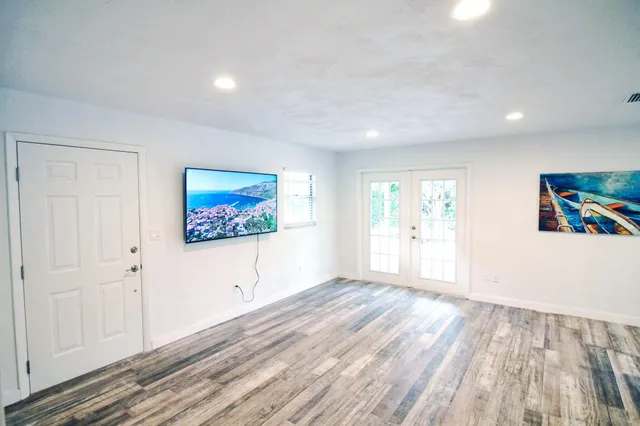 a view of empty room with wooden floor