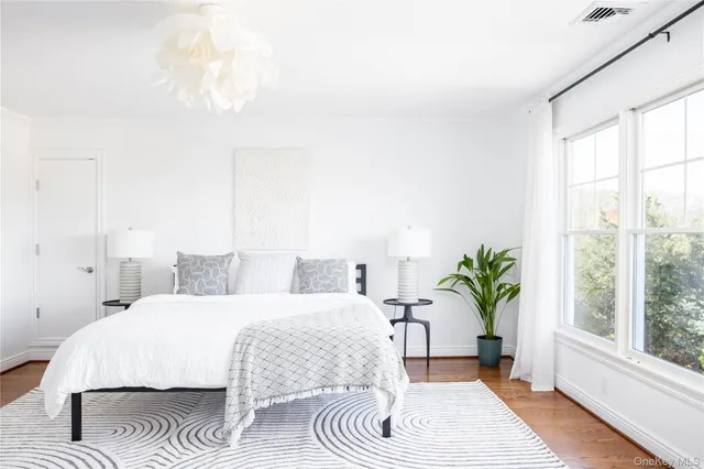 a bedroom with a large bed and a potted plant