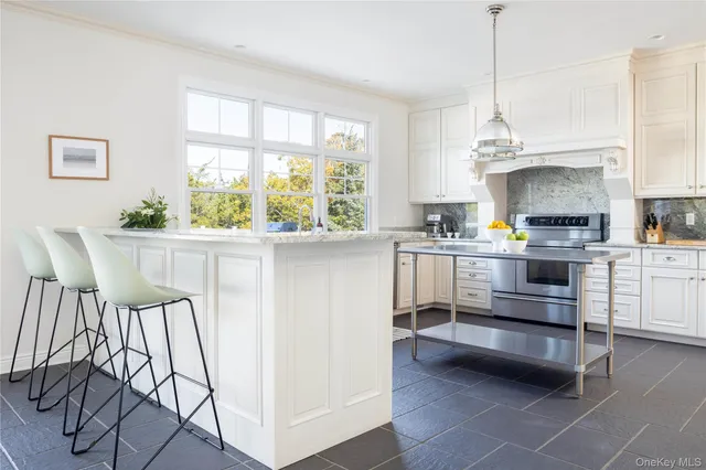 a kitchen with a stove a refrigerator and a view of living room