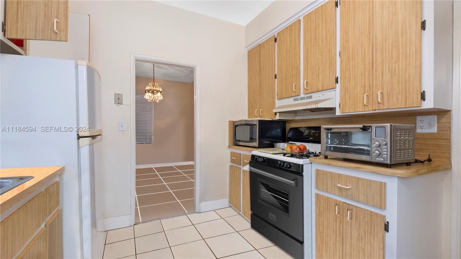 535 West 51st Street Miami Beach, FL 33140 - Photo 14 of 40 a kitchen with stainless steel appliances granite countertop a stove and a refrigerator