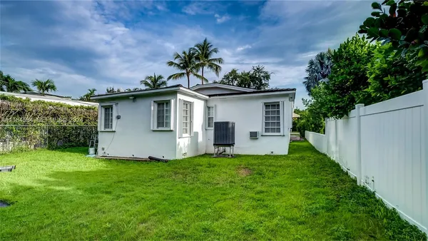 a view of a house with backyard sitting area and garden