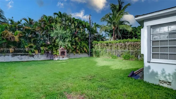 a view of swimming pool with chairs and plants