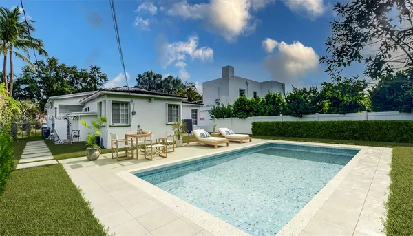 a view of a house with swimming pool and sitting area