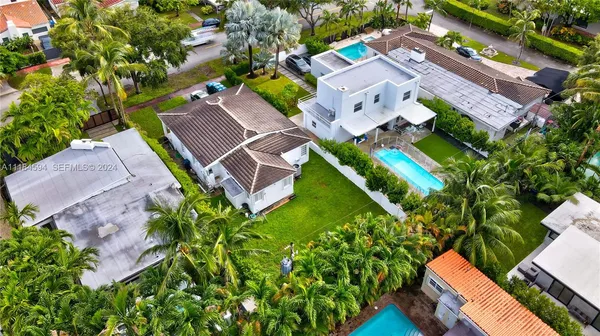 an aerial view of a residential houses with yard