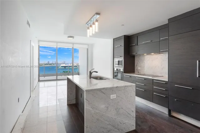 a large kitchen with granite countertop a sink dishwasher stove and cabinets