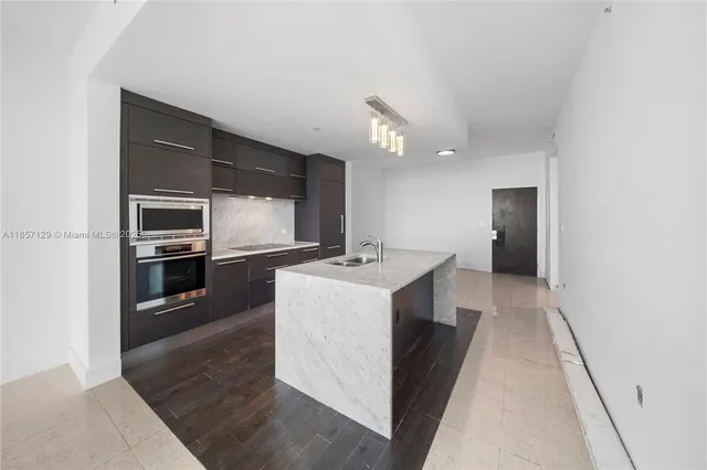 a kitchen with a sink and stainless steel appliances