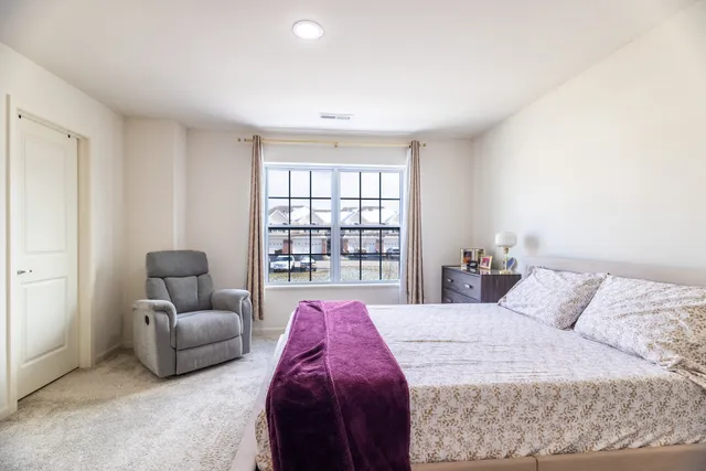 a spacious bedroom with a bed and glass window