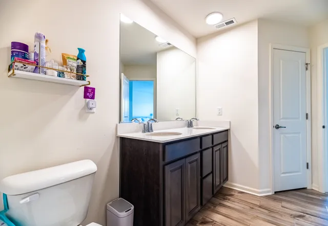 a bathroom with a sink mirror vanity and toilet
