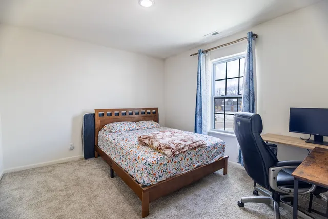 a bedroom with a bed chair and a window
