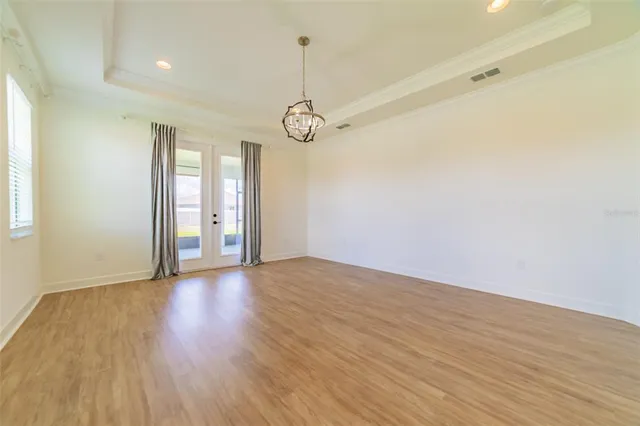 a view of an empty room with wooden floor and closet