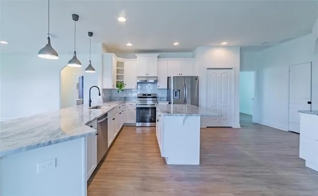 a large kitchen with a large counter top appliances and cabinets