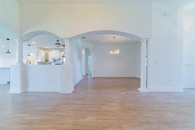 a view of empty room with wooden floor and window