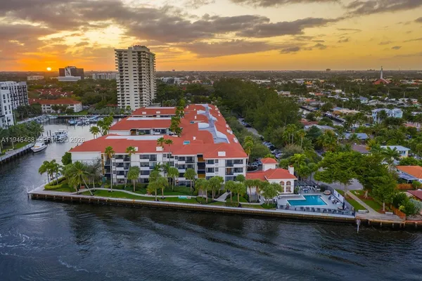 an aerial view of a house with a garden and lake view