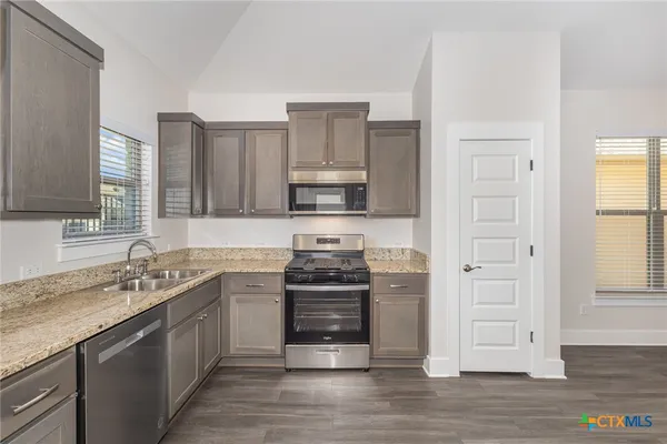 a kitchen with stainless steel appliances granite countertop a stove and a sink