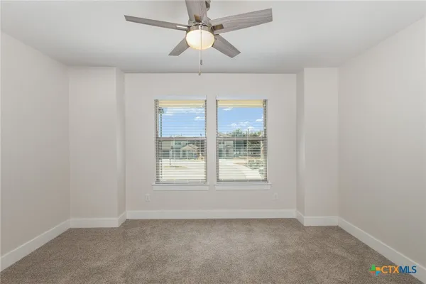 an empty room with a window and a fan