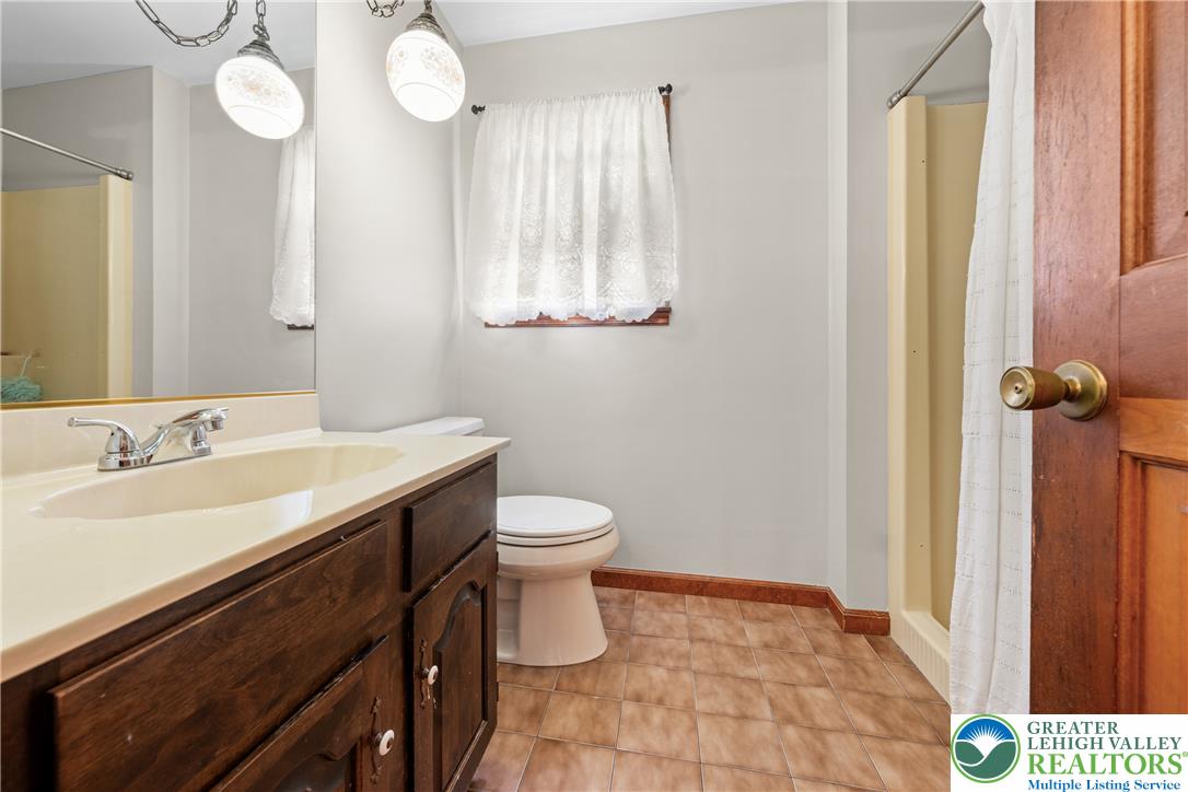947 Tamenend Road Bath, PA 18014 - Photo 27 of 61 A classic tiled bathroom features a functional vanity and a convenient shower.