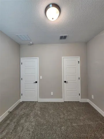 an empty room with closet and mirror
