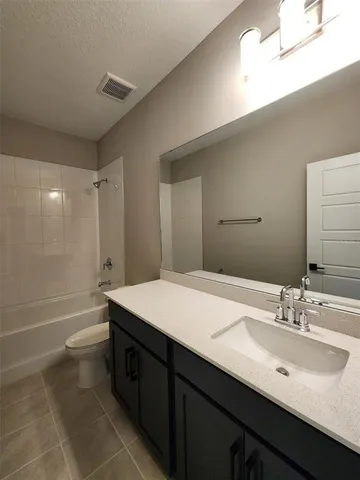 a bathroom with a sink a toilet a mirror and shower