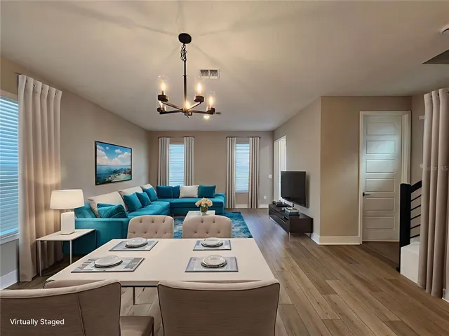 a living room with stainless steel appliances furniture a fireplace and a flat screen tv