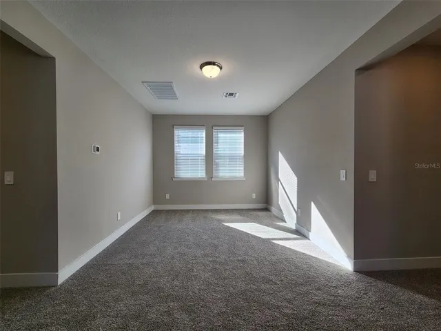 an empty room with windows and closet