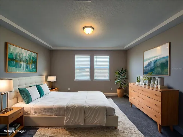 a bedroom with a large bed and a flat tv screen on dresser