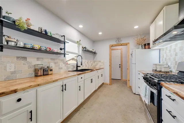 a large kitchen with stainless steel appliances granite countertop a lot of counter space and a sink