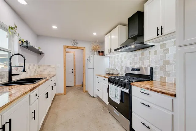 a kitchen with granite countertop a sink stove and cabinets